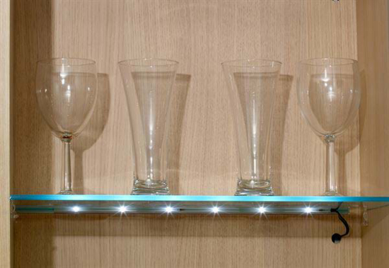 Illuminated glass shelf in a cupboard